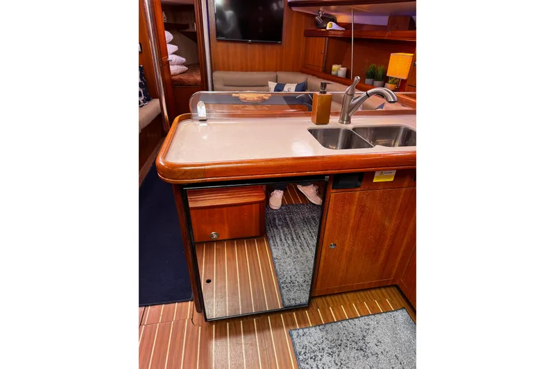 Slide: The Image of Interior of 2007 Hunter 38 yacht featuring a wooden galley with sink and storage. - 13