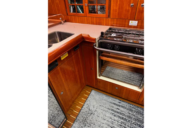 Slide: The Image of 2007 Hunter 38 yacht kitchen with wooden cabinetry, stove, and sink. - 14