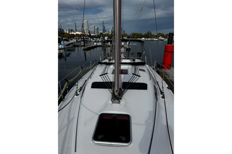 Slide: The Image of 2007 Hunter 38 sailboat docked at marina with city skyline in background. - 2