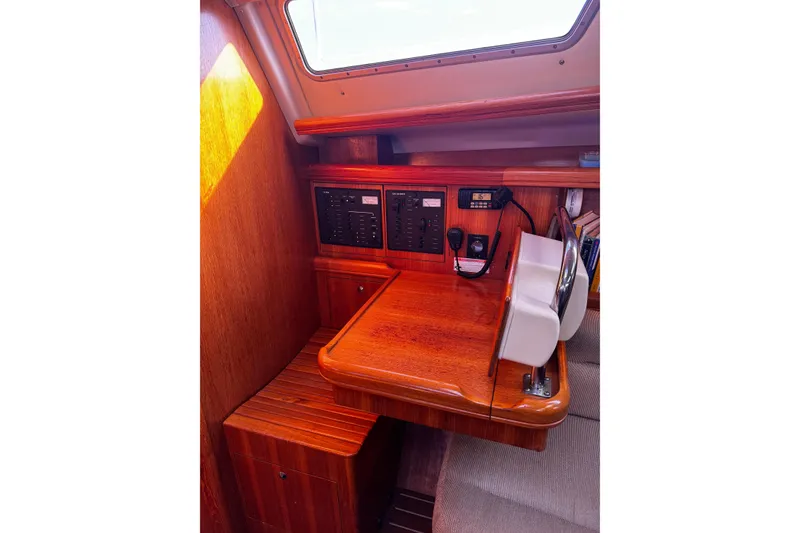 Slide: The Image of 2007 Hunter 38 yacht navigation station with wooden finish and control panels. - 23