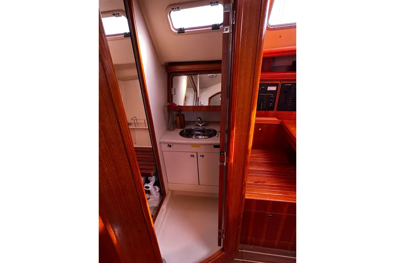 Slide: The Image of Interior of 2007 Hunter 38 sailboat showing compact bathroom with sink and wooden cabinetry. - 28