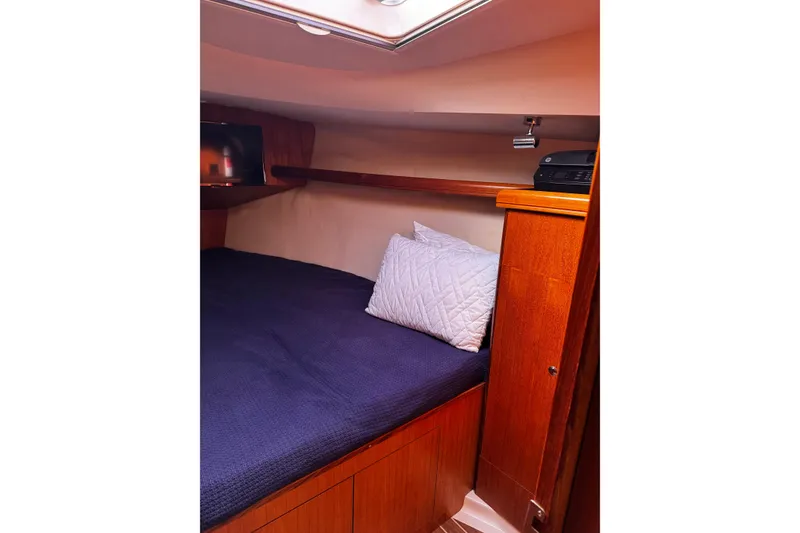 Slide: The Image of Cozy cabin interior of 2007 Hunter 38 sailboat with wooden finish and bedding. - 31