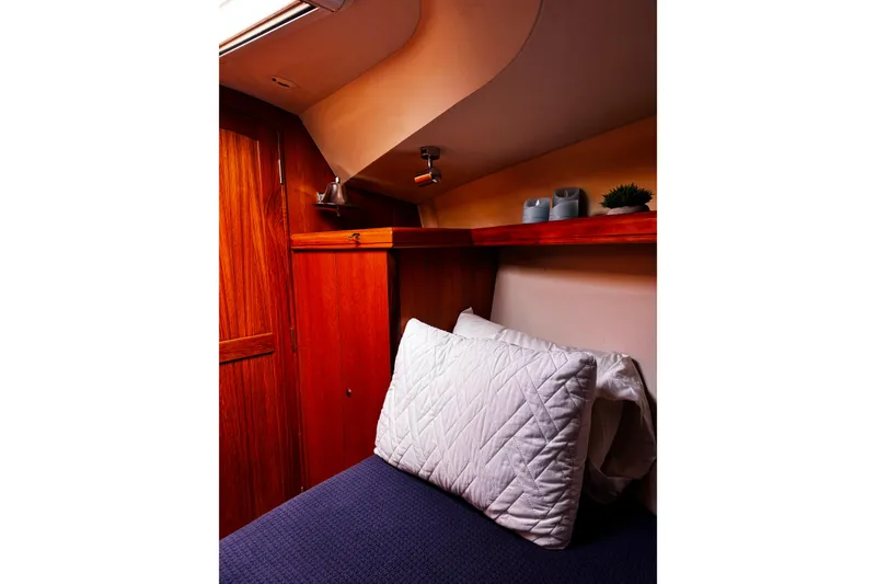 Slide: The Image of Cozy cabin interior of 2007 Hunter 38 sailboat with wooden accents and bedding. - 34