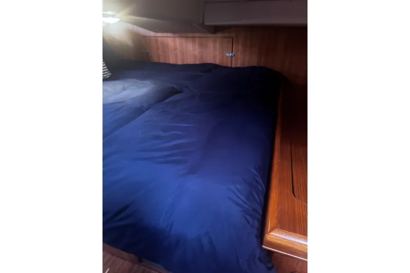 Slide: The Image of Cozy cabin interior of 2007 Hunter 38 sailboat with blue bedding and wooden accents. - 41