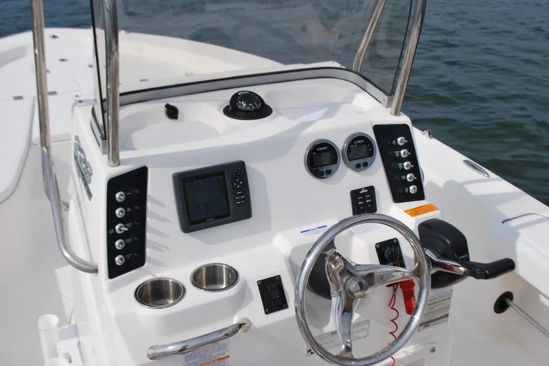Slide: The Image of 2016 Robalo 226 Cayman boat dashboard with steering wheel and navigation controls. - 6