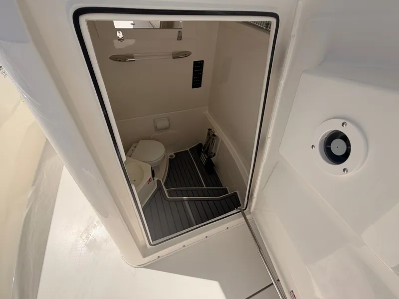 Slide: The Image of Interior of 2026 Cobia 245CC featuring toilet and storage space. - 11