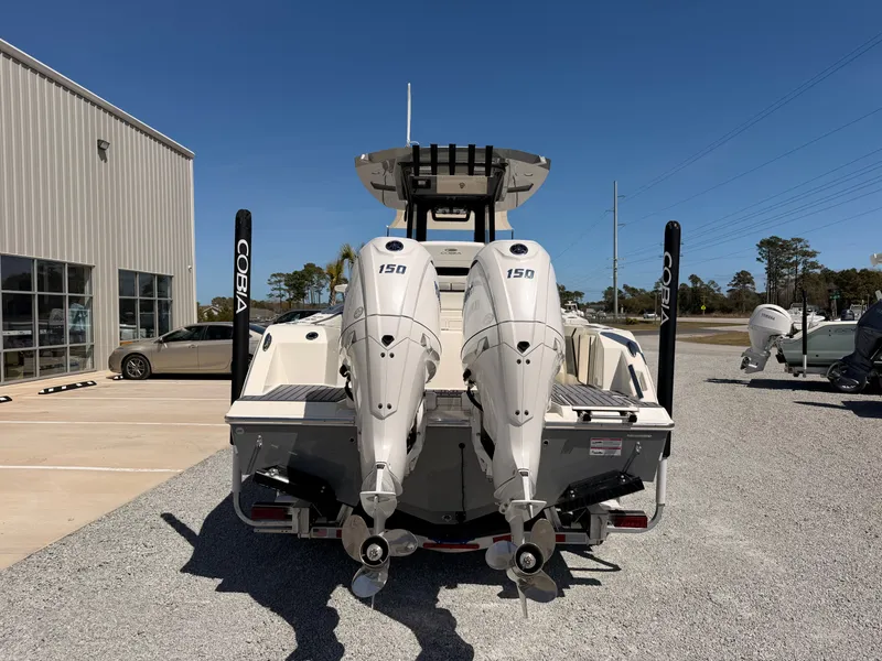 Slide: The Image of Cobia 245CC 2026 with twin outboard engines on gravel lot. - 2