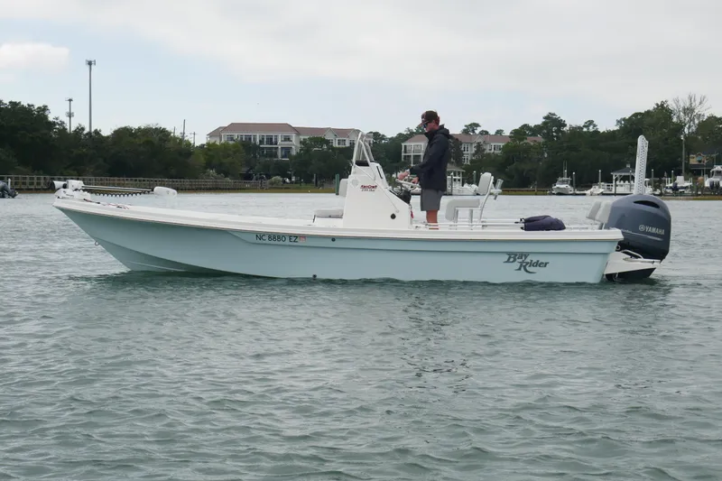 Slide: The Image of 2023 Bay Rider 239 Bay boat on water, person standing, Yamaha engine visible. - 1