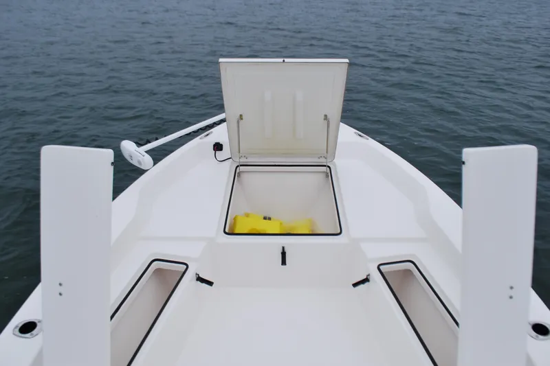 Slide: The Image of 2023 Bay Rider 239 Bay boat with open storage compartment on calm water. - 11