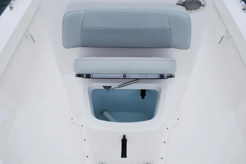 Slide: The Image of 2023 Bay Rider 239 Bay boat interior with cushioned seating and storage compartment. - 12