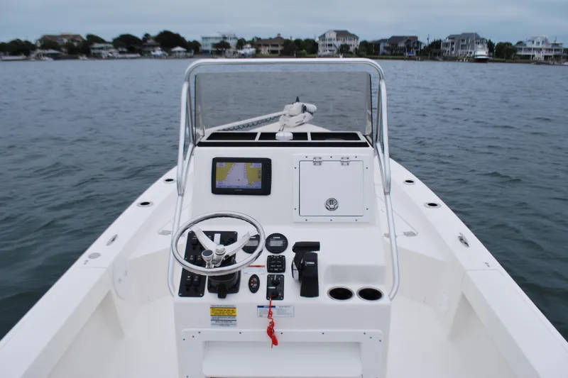 Slide: The Image of 2023 Bay Rider 239 Bay boat dashboard with steering wheel and navigation system on water. - 15