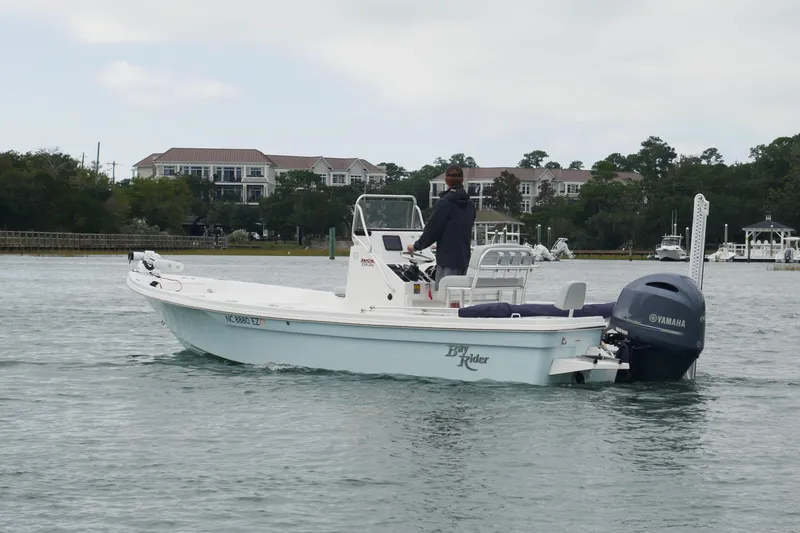 Slide: The Image of 2023 Bay Rider 239 Bay boat cruising on a calm waterway with Yamaha outboard. - 2