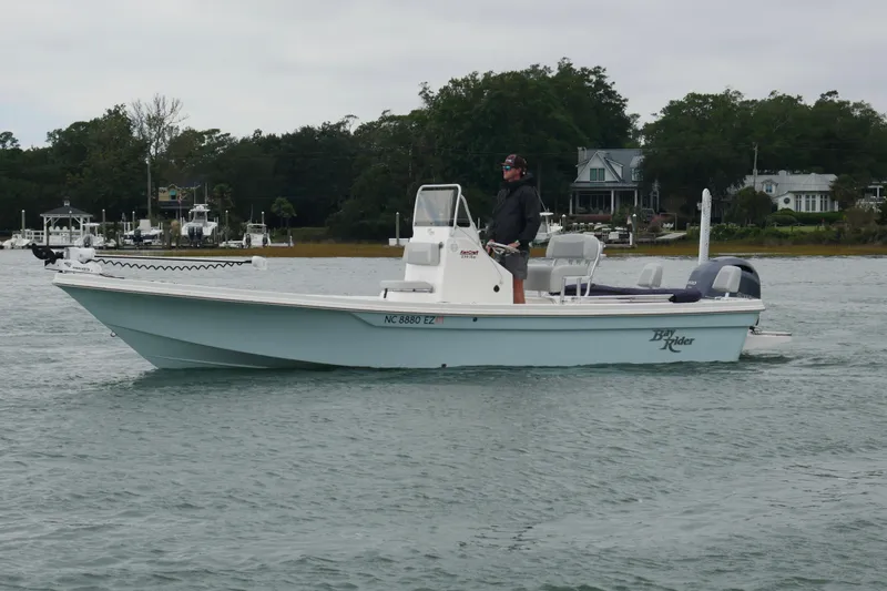 Slide: The Image of 2023 Bay Rider 239 Bay boat cruising on a calm waterway with scenic background. - 3