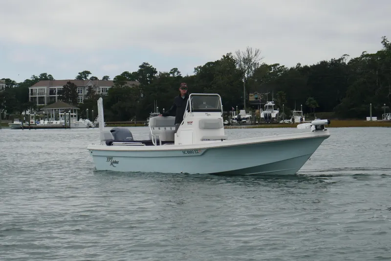 Slide: The Image of 2023 Bay Rider 239 Bay boat cruising on a calm waterway near a marina. - 6