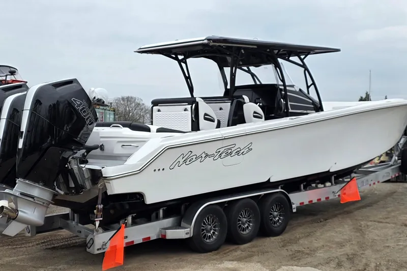 The Image of 2026 Nor-Tech 390 Sport Center Console boat on trailer with powerful outboard engines. - 0