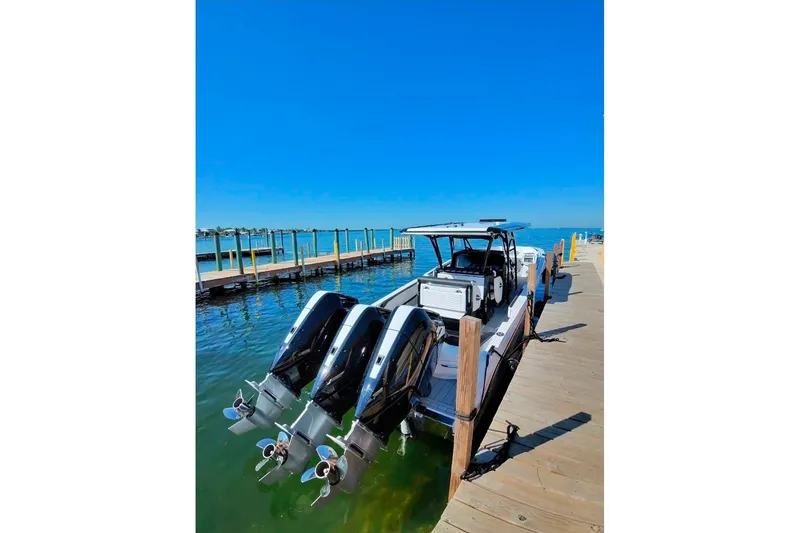 Slide: The Image of 2026 Nor-Tech 390 Sport Center Console docked with triple outboard engines. - 18