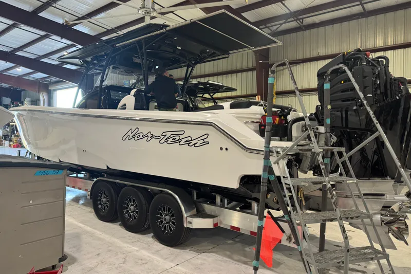 Slide: The Image of 2026 Nor-Tech 390 Sport Center Console boat in a warehouse on a trailer. - 20
