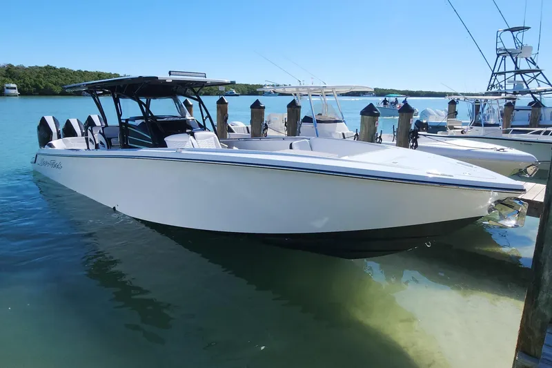Slide: The Image of 2026 Nor-Tech 390 Sport Center Console boat docked in clear blue water. - 3