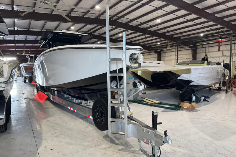 Slide: The Image of 2026 Nor-Tech 390 Sport Center Console boat in a warehouse, on a trailer. - 9