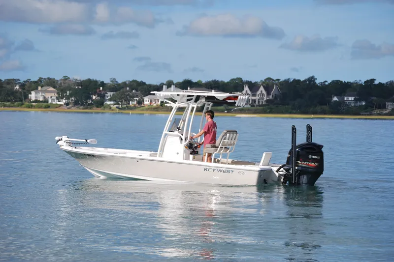 The Image of 2021 Key West 210 Bay Reef boat on calm water, with scenic shoreline background. - 0