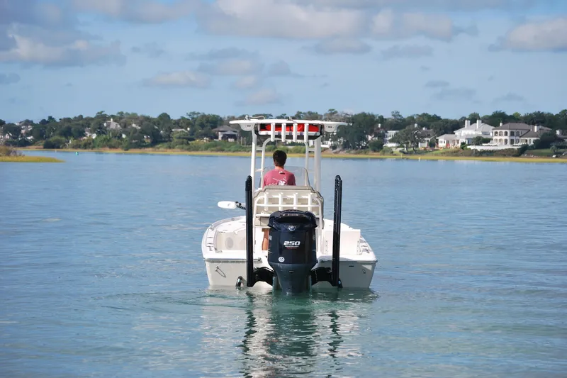 Slide: The Image of 2021 Key West 210 Bay Reef boat cruising on calm water near residential shoreline. - 2