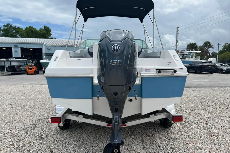 Slide: The Image of 2026 Robalo R207 Dual Console boat with Yamaha 150 engine, parked on gravel. - 3