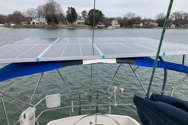 Slide: The Image of Sailboat with solar panels on deck, Wauquiez 38, 1983 model, on a calm lake. - 4