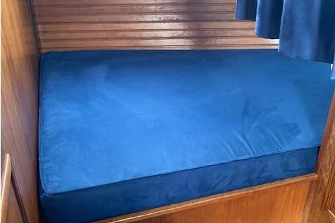 Slide: The Image of Blue cushioned berth in 1983 Wauquiez 38 sailboat cabin. - 5
