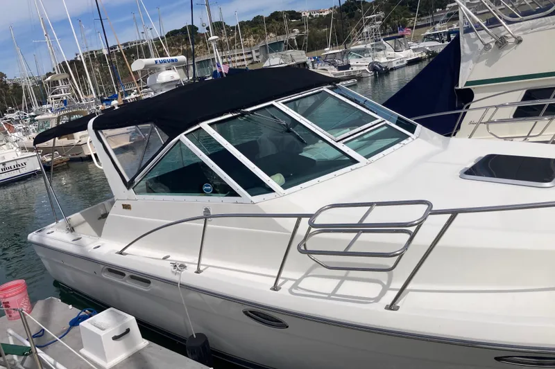 Slide: The Image of 2002 Tiara Yachts 2900 Open docked in a marina, featuring sleek design and black canopy. - 14