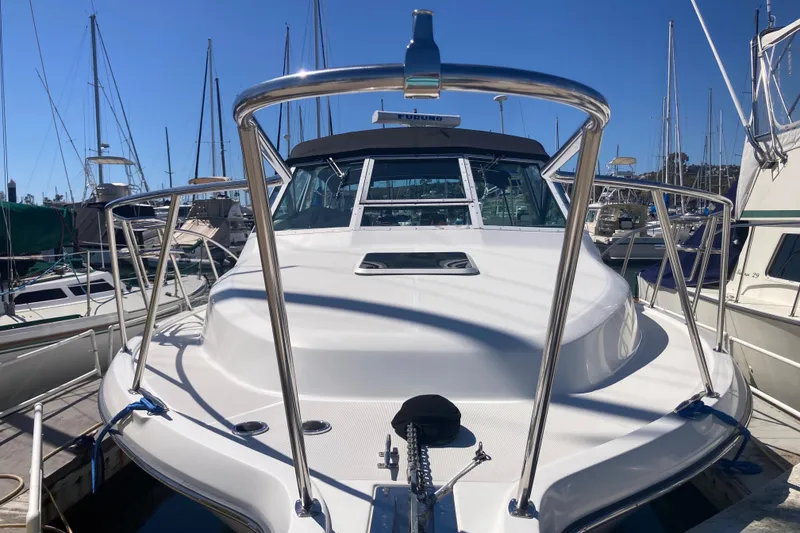 Slide: The Image of 2002 Tiara Yachts 2900 Open docked at marina, showcasing sleek design and stainless steel railings. - 15