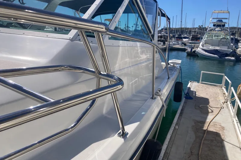 Slide: The Image of 2002 Tiara Yachts 2900 Open docked at marina, showcasing sleek design and stainless steel railings. - 22