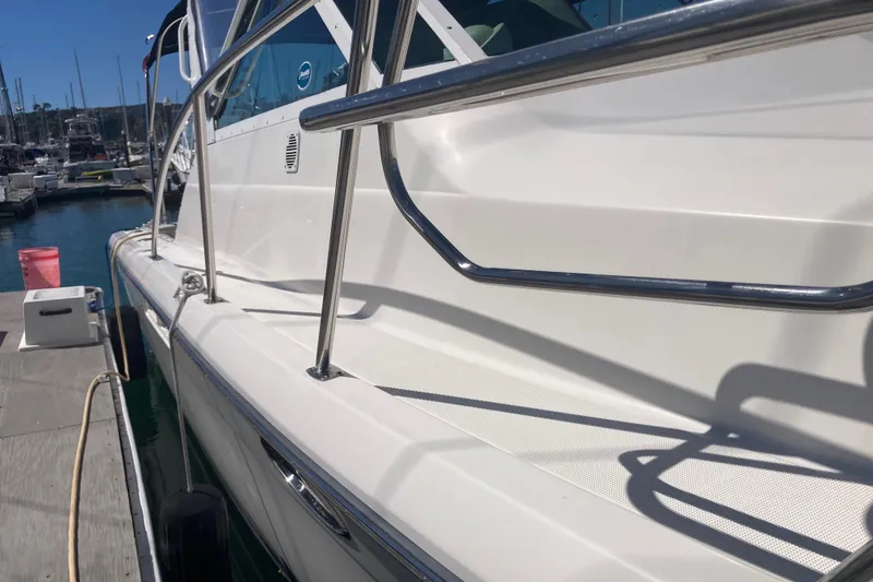 Slide: The Image of 2002 Tiara Yachts 2900 Open docked at marina, showcasing sleek white exterior. - 23