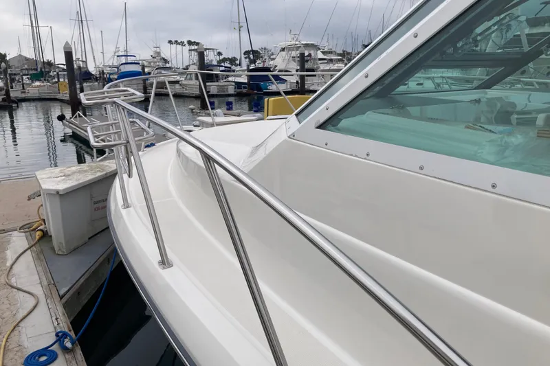 Slide: The Image of 2002 Tiara Yachts 2900 Open docked at marina, showcasing sleek design and stainless steel railings. - 25