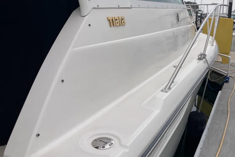 Slide: The Image of 2002 Tiara Yachts 2900 Open docked, showcasing sleek white exterior and railing. - 29