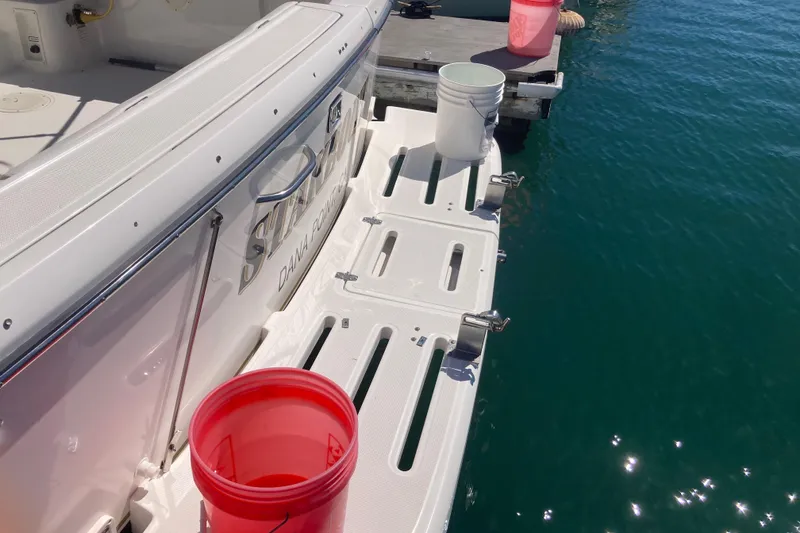 Slide: The Image of 2002 Tiara Yachts 2900 Open at dock with buckets on swim platform. - 34