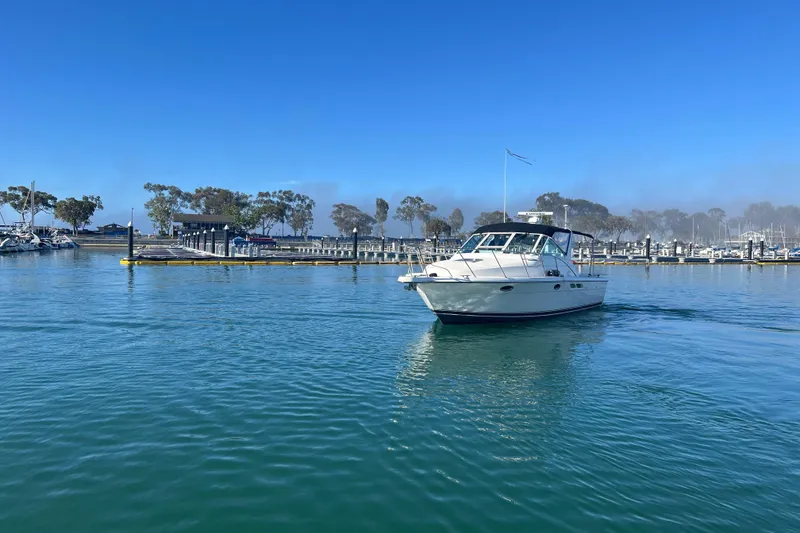 Slide: The Image of 2002 Tiara Yachts 2900 Open cruising in a serene marina under clear blue skies. - 5