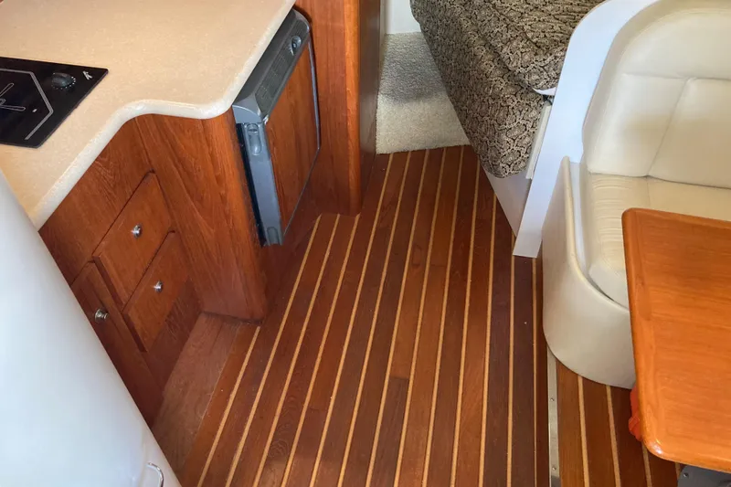 Slide: The Image of Interior of 2002 Tiara Yachts 2900 Open with wood flooring and compact kitchen area. - 57