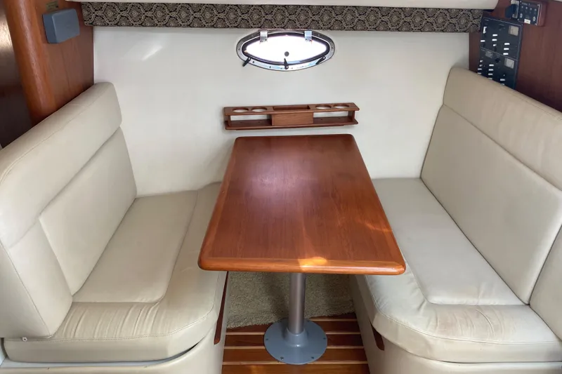 Slide: The Image of Interior of 2002 Tiara Yachts 2900 Open, featuring a cozy dining area with wooden table. - 61