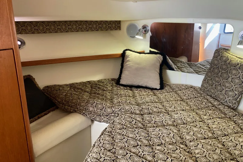 Slide: The Image of Cozy cabin interior of 2002 Tiara Yachts 2900 Open with patterned bedding and pillows. - 64