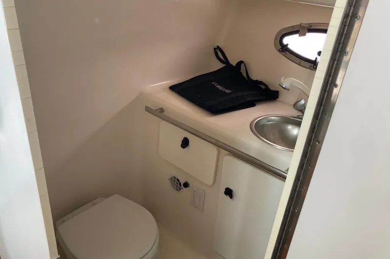 Slide: The Image of 2002 Tiara Yachts 2900 Open bathroom with sink, toilet, and porthole window. - 68