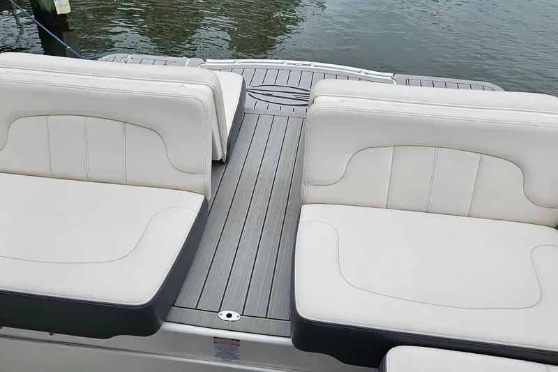 Slide: The Image of 2018 Chaparral 257 SSX boat with white seating and gray deck by the water. - 11