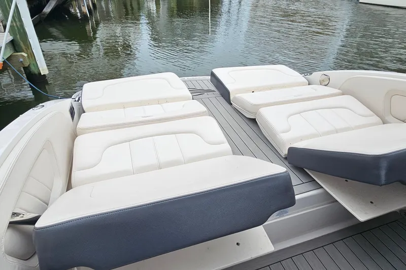 Slide: The Image of 2018 Chaparral 257 SSX boat with luxurious white seating on a calm waterfront. - 13