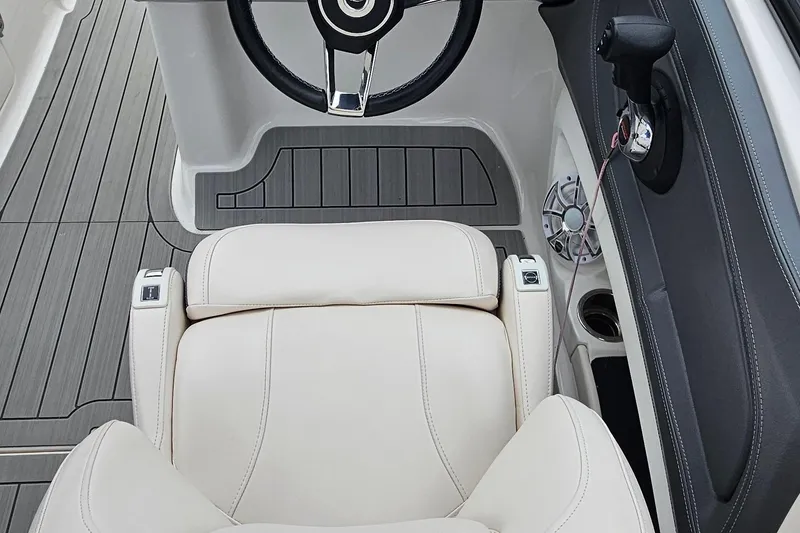 Slide: The Image of 2018 Chaparral 257 SSX boat interior with steering wheel and beige seating. - 14