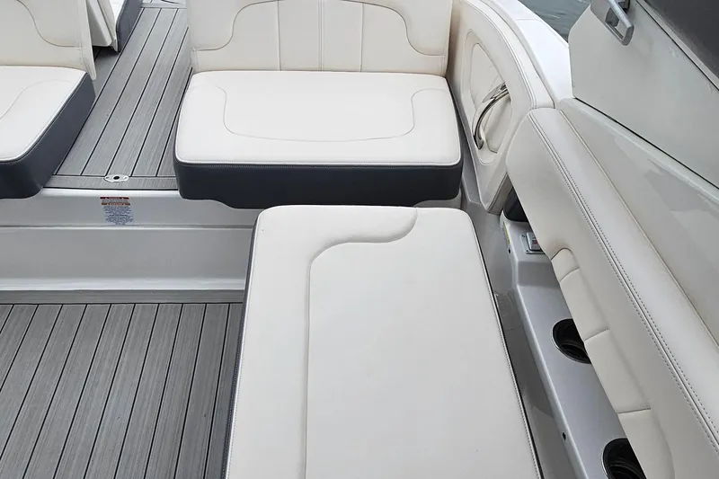 Slide: The Image of 2018 Chaparral 257 SSX boat interior with white cushioned seating and gray flooring. - 16