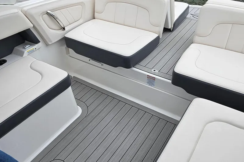 Slide: The Image of 2018 Chaparral 257 SSX boat interior with white cushioned seating and gray flooring. - 17