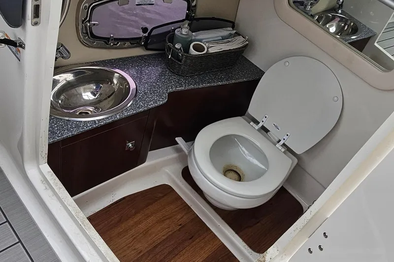 Slide: The Image of 2018 Chaparral 257 SSX boat bathroom with sink, toilet, and wooden flooring. - 9