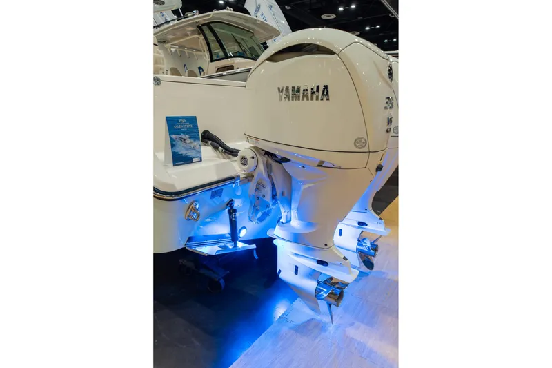 Slide: The Image of 2026 Grady-White Canyon 306 boat with Yamaha outboard engines, illuminated by blue lights. - 6