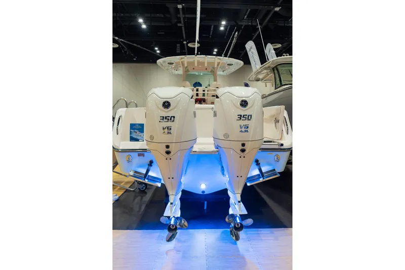 Slide: The Image of 2026 Grady-White Canyon 306 boat with twin 350 V6 engines displayed indoors. - 7