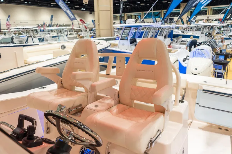 Slide: The Image of 2026 Grady-White Canyon 306 boat interior with luxurious seating at a boat show. - 9