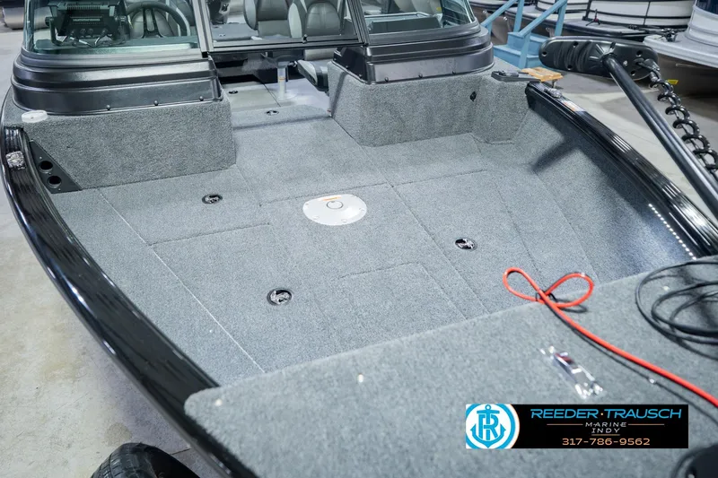 Slide: The Image of 2026 Lund 1775 Impact XS boat interior with gray carpet and seating area. - 12